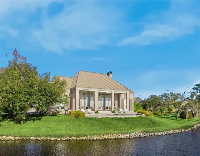 rear view of house featuring a patio area, a water view, and a yard