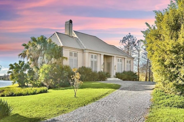 view of front facade with a water view and a lawn