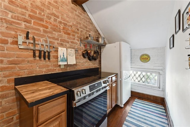 kitchen with lofted ceiling, brick wall, and stainless steel electric range