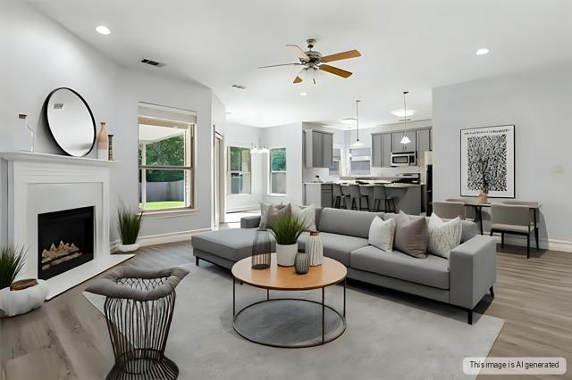 living area featuring recessed lighting, visible vents, a fireplace with raised hearth, light wood-style flooring, and baseboards