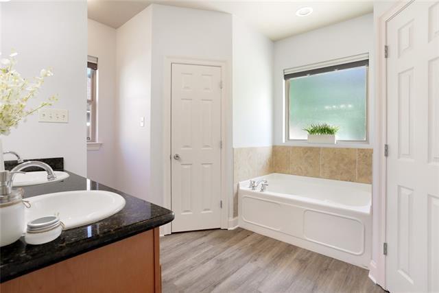 bathroom featuring a bath, wood finished floors, and vanity