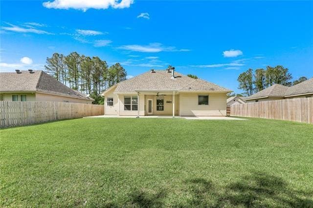 rear view of property with a yard, a fenced backyard, and a patio