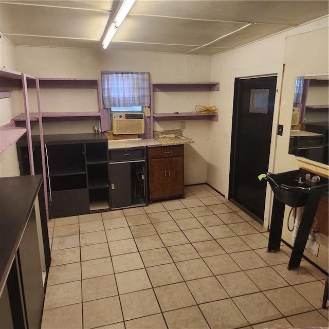 kitchen featuring dark brown cabinets, cooling unit, and light tile patterned floors