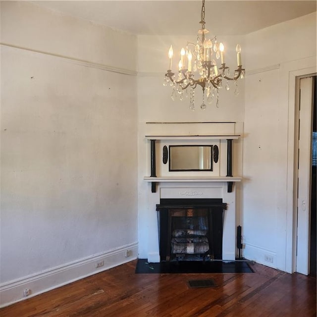 unfurnished living room with hardwood / wood-style floors and a notable chandelier