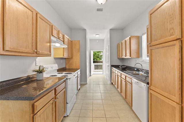 kitchen with dark stone countertops, sink, white appliances, light tile patterned flooring, and light brown cabinetry