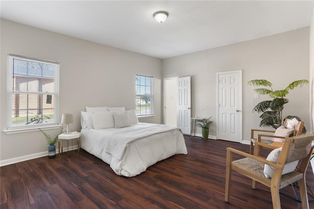 bedroom with dark wood-type flooring and multiple windows