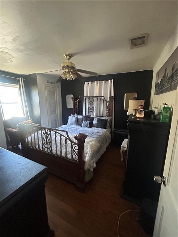 bedroom with ceiling fan and dark hardwood / wood-style flooring