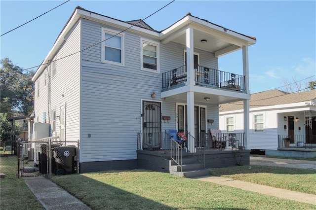 view of front of home featuring a balcony, a front lawn, and covered porch