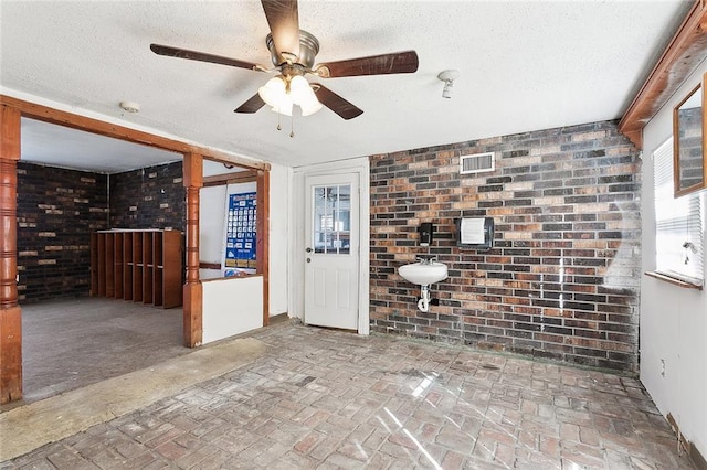 interior space with a textured ceiling and sink