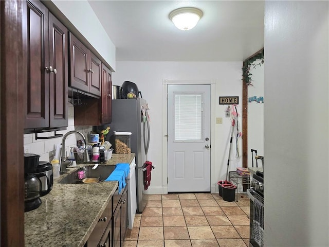 kitchen featuring black range with electric stovetop, sink, light stone counters, decorative backsplash, and light tile patterned flooring