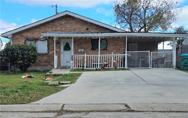 bungalow-style house with a front yard, a porch, and a carport