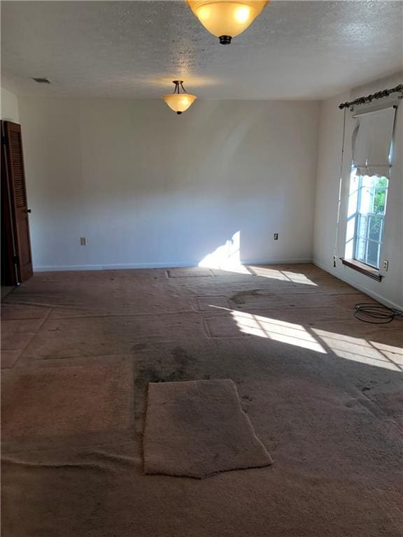 unfurnished room featuring a textured ceiling