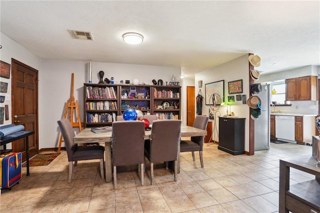 dining space with light tile patterned floors and a textured ceiling