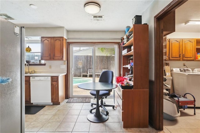 tiled office space with washer and clothes dryer, a textured ceiling, and sink