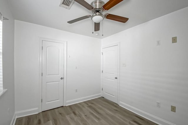 unfurnished bedroom featuring visible vents, ceiling fan, baseboards, and wood finished floors