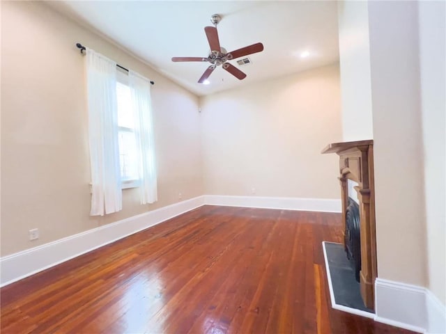 unfurnished living room featuring ceiling fan and dark hardwood / wood-style floors