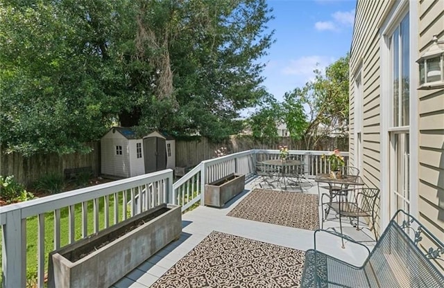 wooden deck with a storage unit and a patio