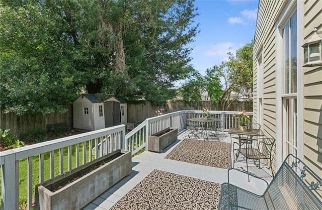 wooden terrace with a patio area and a storage shed