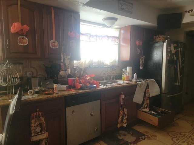 kitchen with black refrigerator, stainless steel dishwasher, and sink