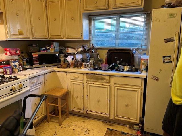 kitchen featuring light brown cabinets, white appliances, and sink