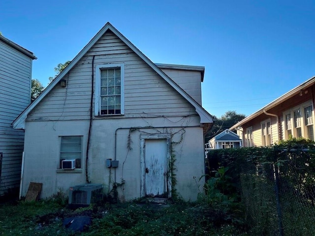 rear view of house with central air condition unit and cooling unit