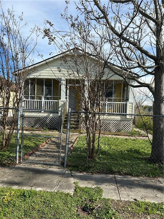 view of front of home with covered porch, a fenced front yard, and a gate