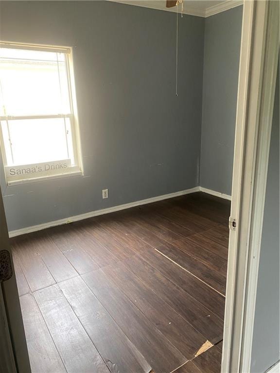 spare room featuring baseboards and dark wood-style floors