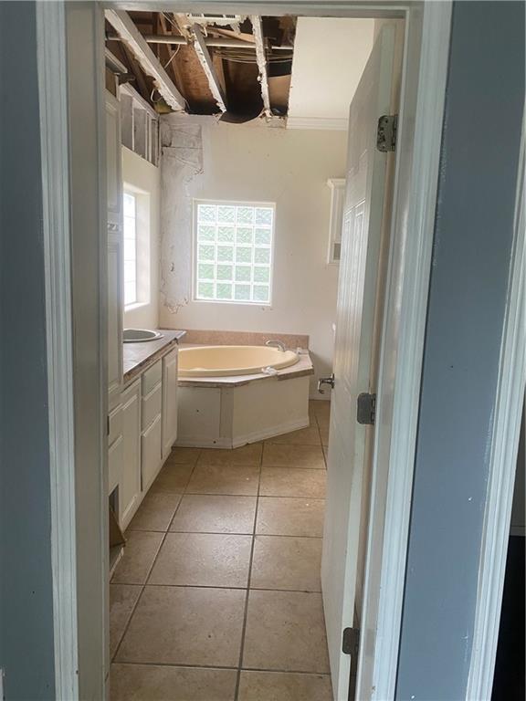full bathroom with a bath, ornamental molding, tile patterned flooring, and vanity