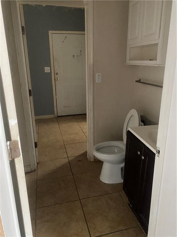 bathroom with tile patterned flooring, vanity, and toilet