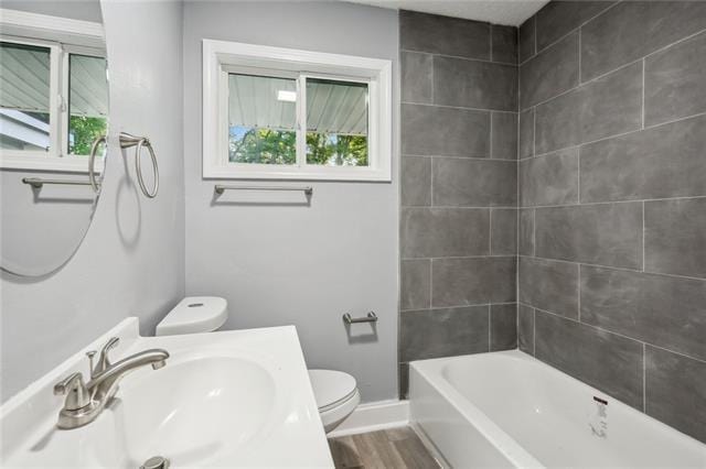 full bathroom featuring shower / tub combination, hardwood / wood-style flooring, toilet, and sink