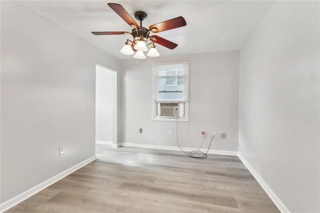 spare room with ceiling fan, cooling unit, and wood-type flooring