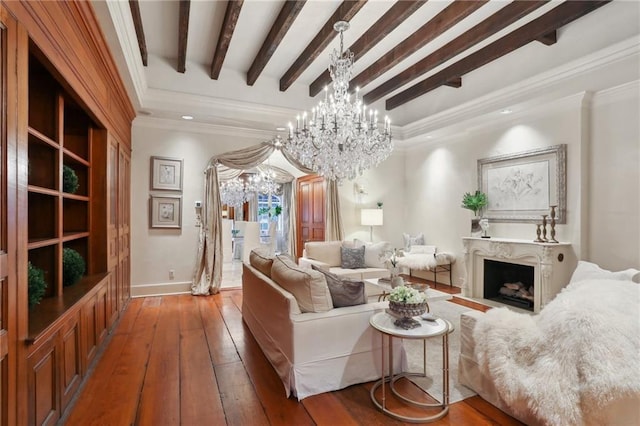 living room with an inviting chandelier, beamed ceiling, hardwood / wood-style floors, a fireplace, and ornamental molding