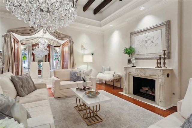 living room featuring a high end fireplace, beamed ceiling, a notable chandelier, crown molding, and light hardwood / wood-style floors