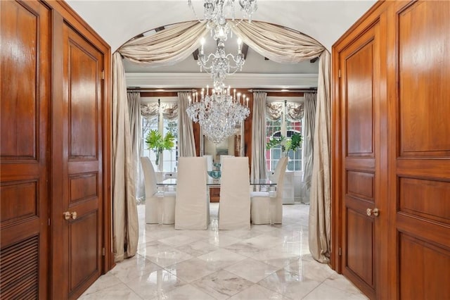 corridor with a notable chandelier and crown molding