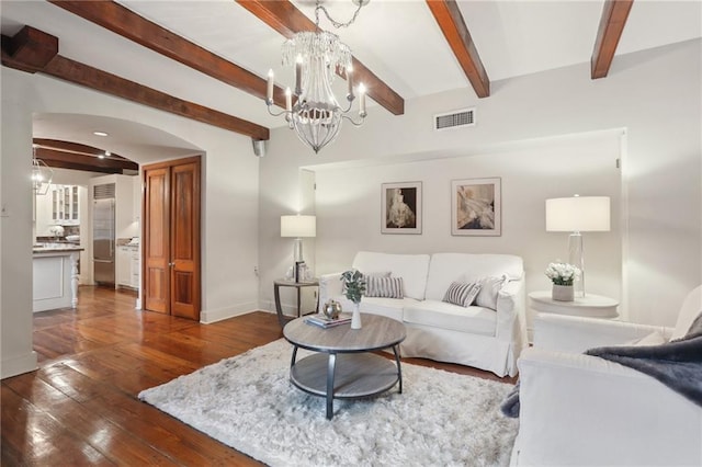 living room with beam ceiling, dark wood-type flooring, and a notable chandelier