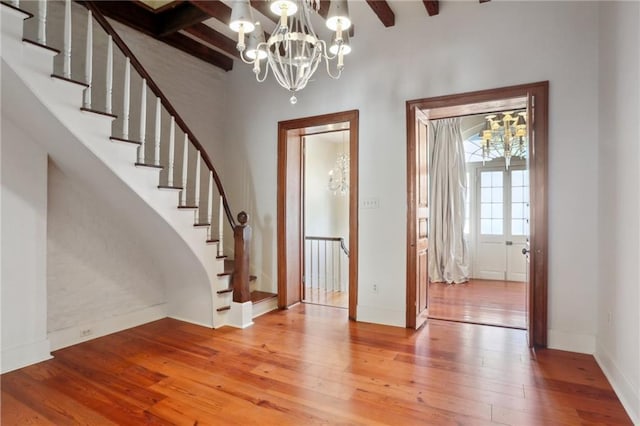 entryway with beamed ceiling, a chandelier, hardwood / wood-style flooring, and coffered ceiling