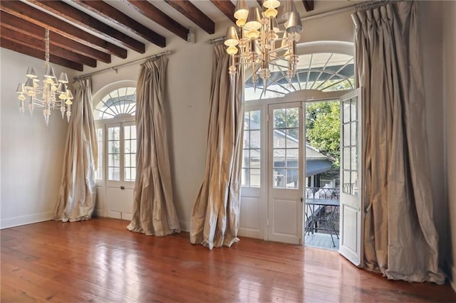 doorway featuring beam ceiling, a notable chandelier, and hardwood / wood-style floors