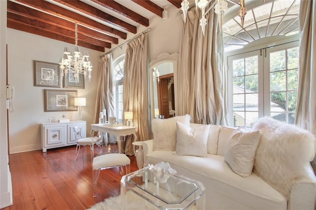 sitting room featuring beam ceiling, wood-type flooring, and a notable chandelier