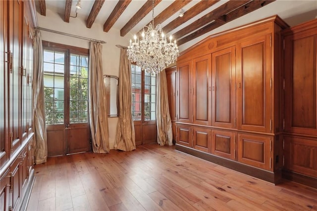 miscellaneous room featuring vaulted ceiling with beams, a healthy amount of sunlight, wood-type flooring, and a chandelier