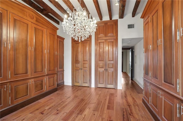 interior space featuring beam ceiling, an inviting chandelier, and hardwood / wood-style floors