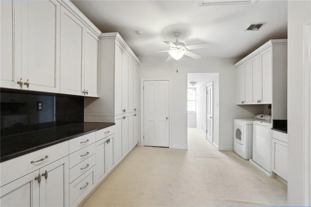 clothes washing area featuring washer and clothes dryer, ceiling fan, cabinets, and light colored carpet