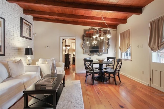 living room featuring beam ceiling, a chandelier, light hardwood / wood-style flooring, and wood ceiling