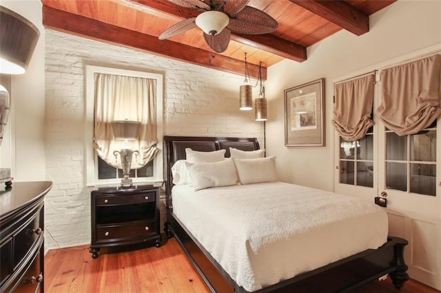 bedroom with beamed ceiling, hardwood / wood-style floors, ceiling fan, and wooden ceiling