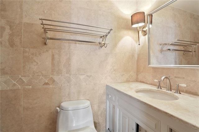 bathroom featuring vanity, tile walls, and toilet