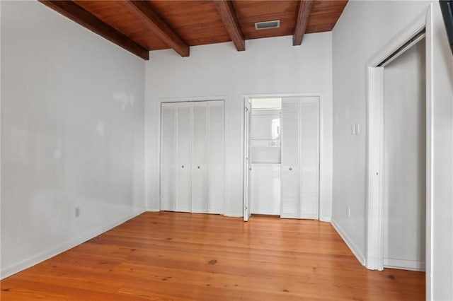 unfurnished bedroom featuring beam ceiling, light hardwood / wood-style flooring, and wooden ceiling