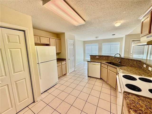 kitchen with light brown cabinets, white appliances, sink, a textured ceiling, and light tile patterned flooring