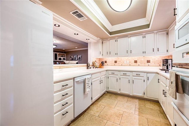 kitchen featuring backsplash, white cabinets, a tray ceiling, crown molding, and white appliances