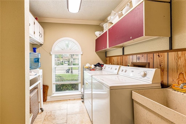 laundry area with sink, light tile patterned floors, washer and clothes dryer, cabinets, and a textured ceiling