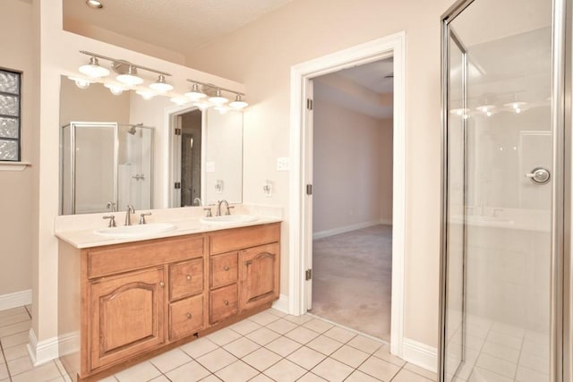 bathroom with tile patterned flooring, vanity, a textured ceiling, and a shower with shower door