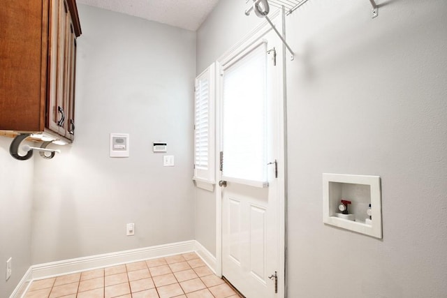 laundry area with cabinets, hookup for a washing machine, and light tile patterned floors